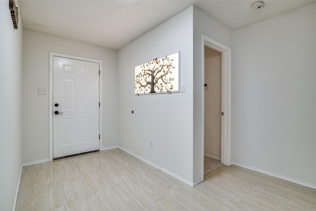 entrance foyer with a textured ceiling and baseboards