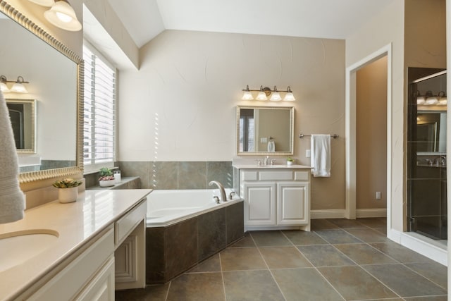 bathroom featuring vaulted ceiling, a garden tub, a sink, and tile patterned floors