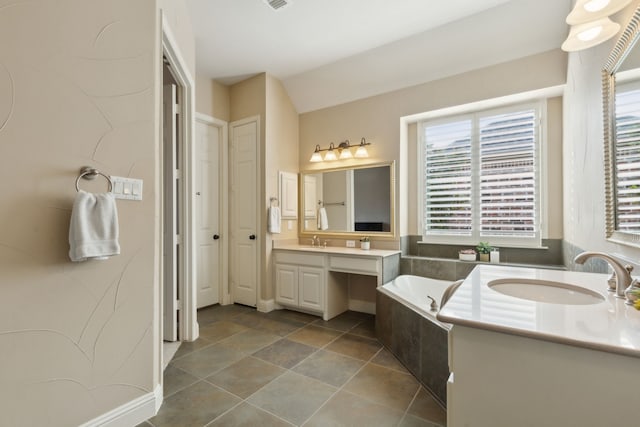 full bathroom featuring visible vents, vaulted ceiling, vanity, a bath, and tile patterned floors