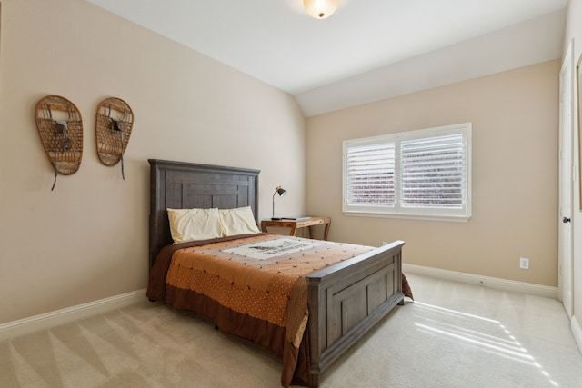 bedroom featuring light carpet, lofted ceiling, and baseboards