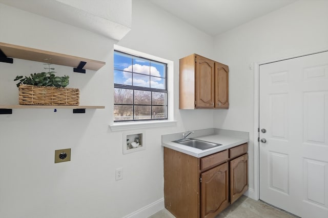 clothes washing area featuring a sink, cabinet space, baseboards, hookup for an electric dryer, and hookup for a washing machine