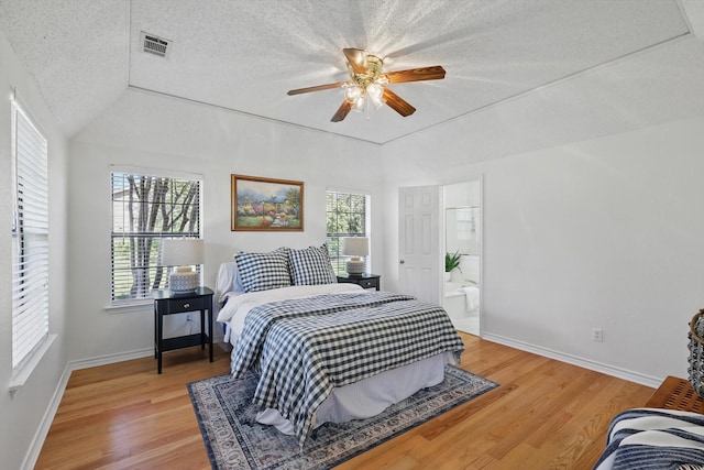 bedroom with light wood-style flooring, multiple windows, visible vents, and a textured ceiling