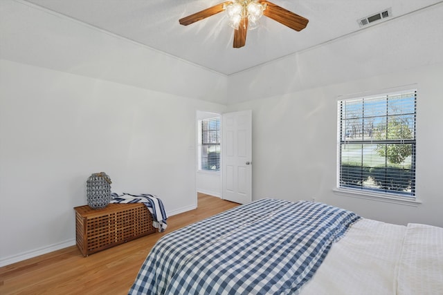 bedroom with baseboards, visible vents, light wood finished floors, and ceiling fan