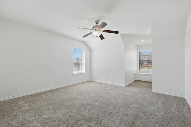 carpeted spare room with baseboards, lofted ceiling, and a ceiling fan