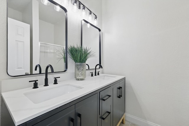 bathroom with a sink, baseboards, and double vanity