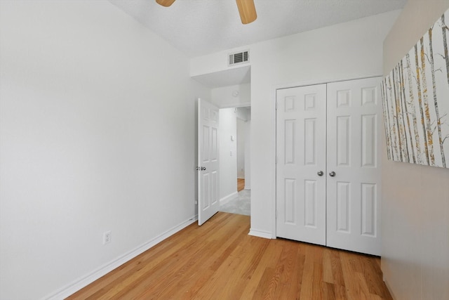 unfurnished bedroom featuring visible vents, light wood-style flooring, a closet, baseboards, and ceiling fan