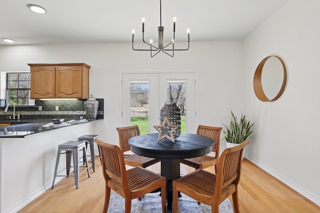 dining space with plenty of natural light, french doors, and light wood-style floors