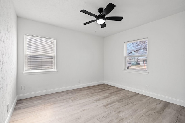 unfurnished room with light wood-type flooring, ceiling fan, and baseboards