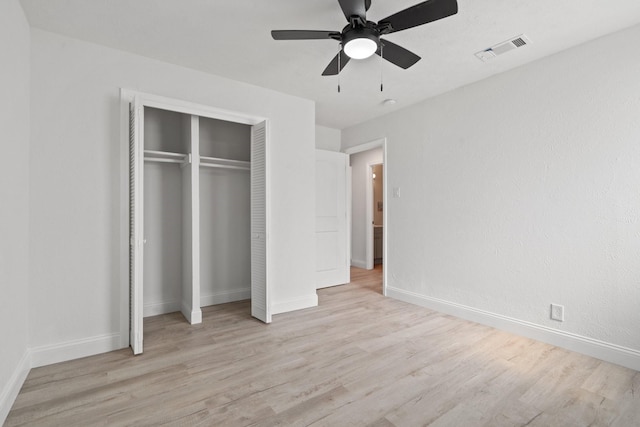 unfurnished bedroom with a ceiling fan, visible vents, baseboards, a closet, and light wood-type flooring