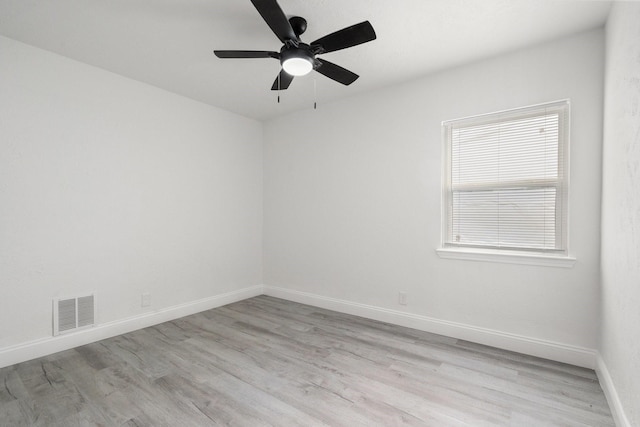 unfurnished room with light wood-type flooring, baseboards, visible vents, and ceiling fan