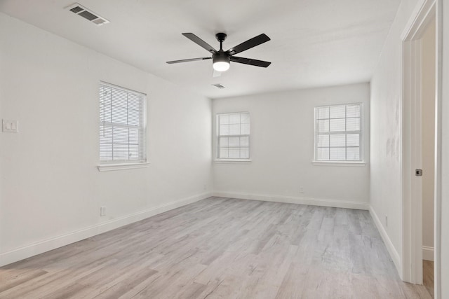 unfurnished room with light wood-style floors, baseboards, visible vents, and a ceiling fan