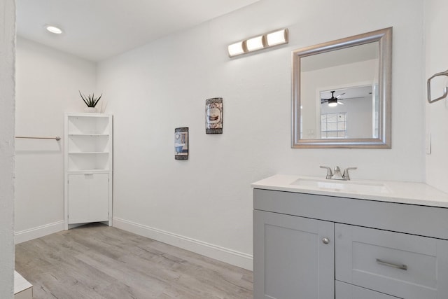 bathroom with wood finished floors, vanity, and baseboards