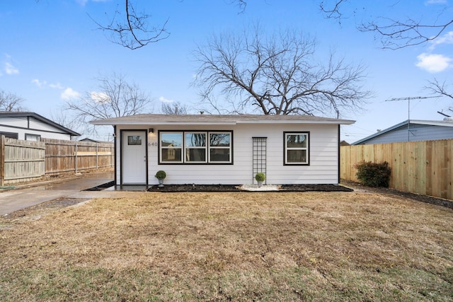 view of front of home with a front yard and fence