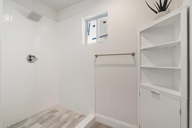 full bath with tiled shower and wood finish floors