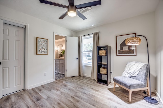 living area with ceiling fan, baseboards, and wood finished floors