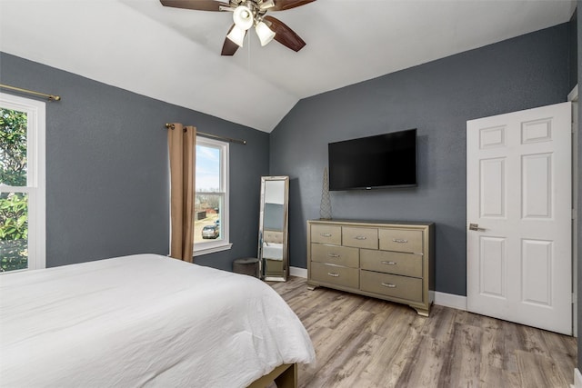 bedroom featuring vaulted ceiling, ceiling fan, light wood finished floors, and baseboards