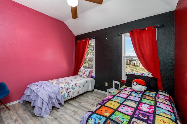 bedroom with a ceiling fan, vaulted ceiling, baseboards, and wood finished floors