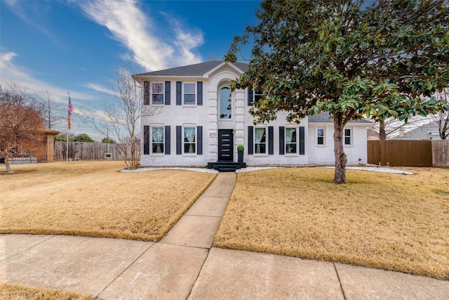 colonial house with fence and a front lawn