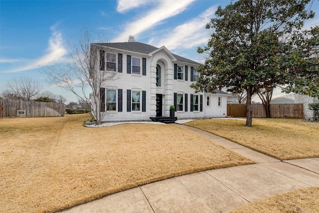 2702 Kingsbury Dr, Garland, TX 75040 - colonial house featuring a front yard, a chimney, and fence