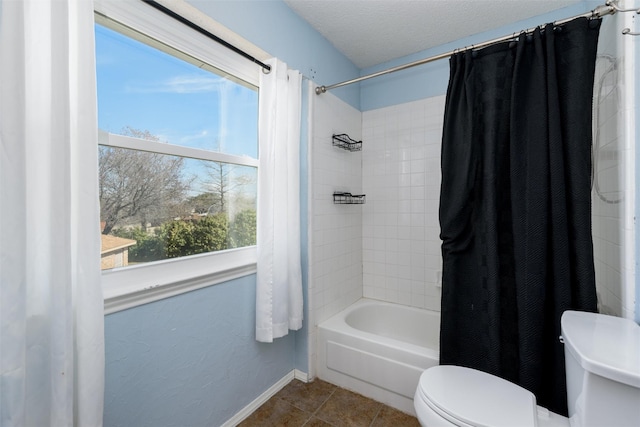 full bathroom with shower / bath combo, baseboards, toilet, tile patterned flooring, and a textured ceiling