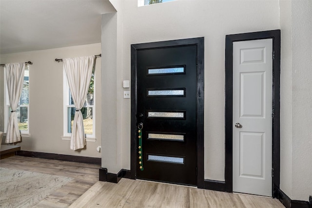 foyer with baseboards and light wood-style floors