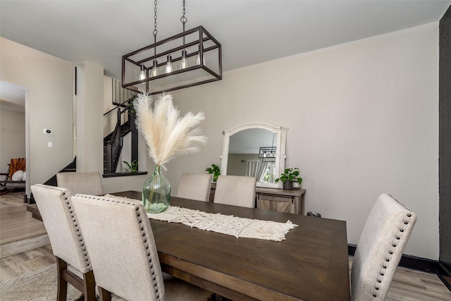 dining room featuring light wood-type flooring and arched walkways