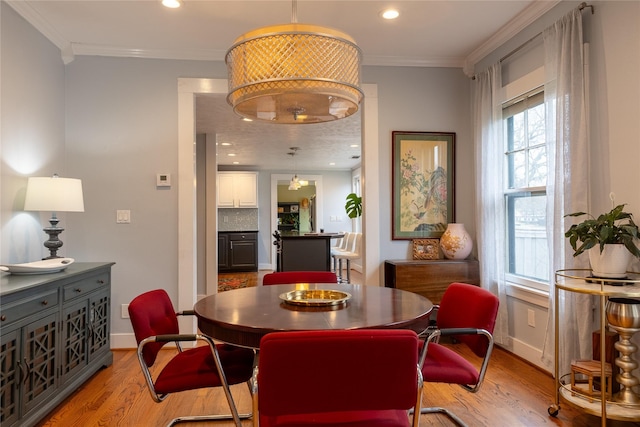 dining area featuring baseboards, recessed lighting, light wood-style flooring, and crown molding