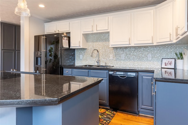 kitchen featuring black appliances, backsplash, a sink, and white cabinets