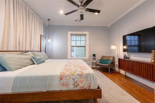 bedroom featuring visible vents, a ceiling fan, ornamental molding, wood finished floors, and recessed lighting