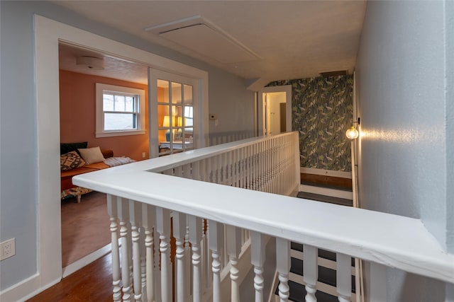 hall featuring baseboards, dark wood finished floors, and an upstairs landing