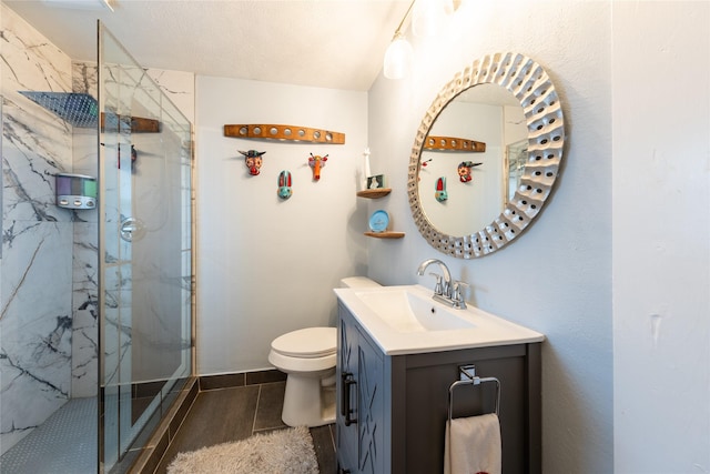 full bathroom with a marble finish shower, vanity, and toilet