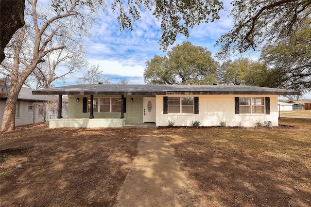 ranch-style house with covered porch and a front lawn