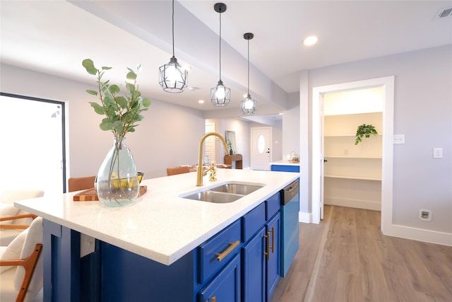 kitchen with light stone counters, decorative light fixtures, blue cabinetry, stainless steel dishwasher, and a sink