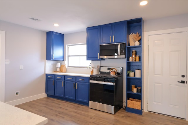 kitchen with blue cabinets, stainless steel appliances, light countertops, light wood-style floors, and open shelves