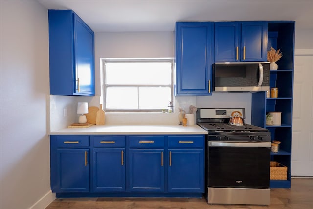 kitchen featuring appliances with stainless steel finishes, light countertops, blue cabinets, and open shelves