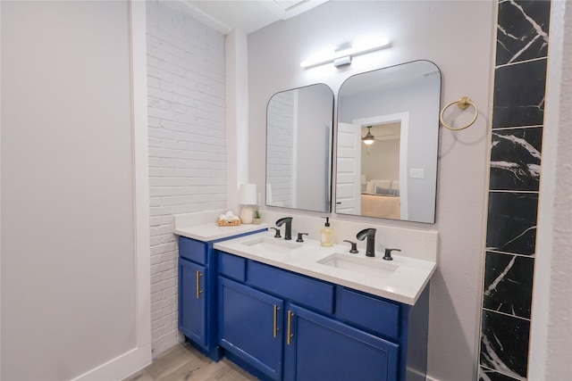 bathroom with double vanity, a sink, and wood finished floors