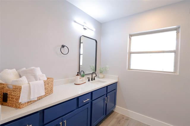 bathroom with baseboards, wood finished floors, and vanity