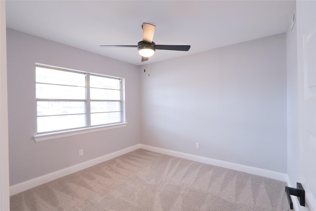 carpeted spare room featuring visible vents, baseboards, and a ceiling fan