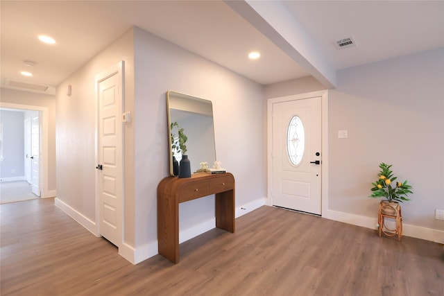 foyer featuring baseboards, visible vents, wood finished floors, and recessed lighting