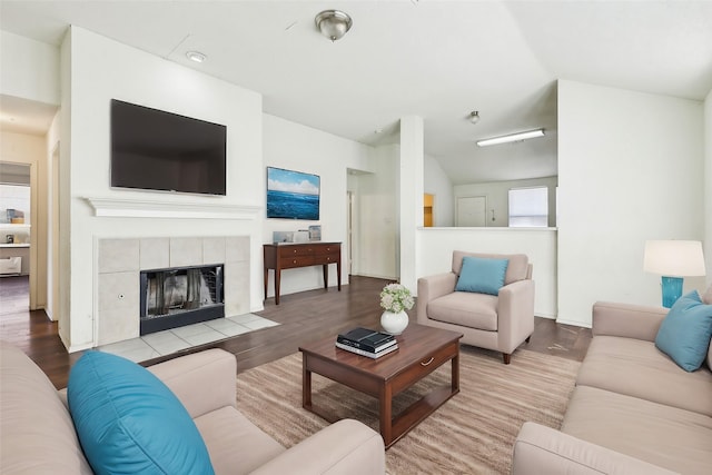 living room with lofted ceiling, light wood finished floors, and a fireplace