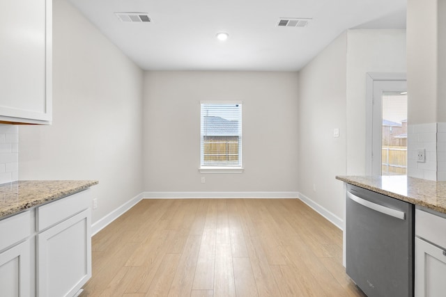 unfurnished dining area featuring light wood-type flooring, visible vents, and baseboards