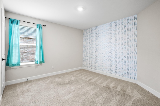 unfurnished room featuring carpet floors and baseboards