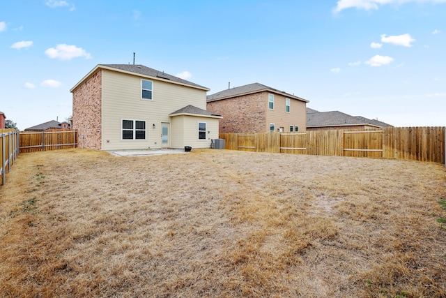 rear view of house featuring cooling unit, a fenced backyard, and a patio