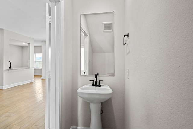 bathroom featuring baseboards, visible vents, and wood finished floors