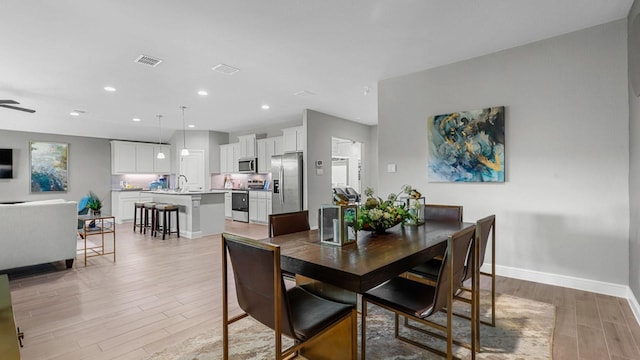 dining area with recessed lighting, visible vents, light wood-style flooring, and baseboards