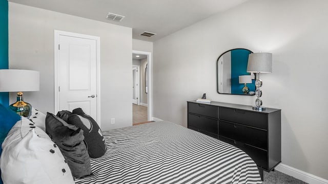 bedroom with visible vents, light carpet, and baseboards