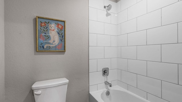 bathroom featuring a textured wall, toilet, and shower / bathtub combination