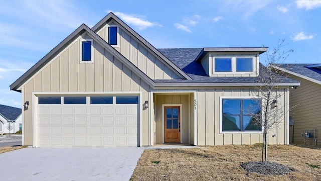 view of front of house featuring a garage, concrete driveway, board and batten siding, and roof with shingles