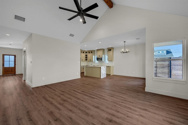 unfurnished living room with visible vents, dark wood-style floors, beam ceiling, a sink, and ceiling fan with notable chandelier