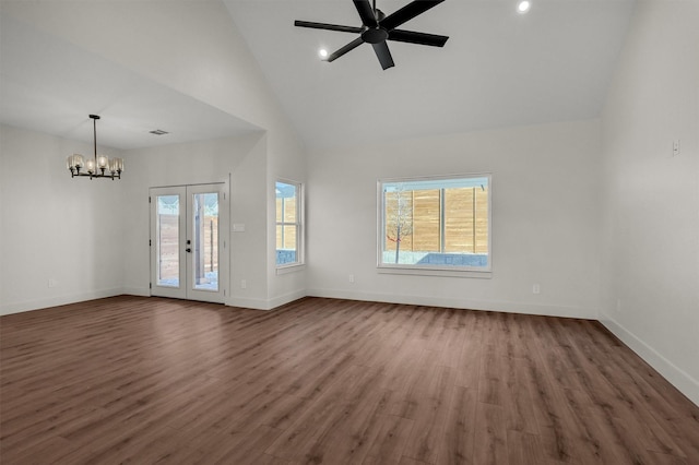 unfurnished living room featuring high vaulted ceiling, dark wood-style flooring, a wealth of natural light, and baseboards